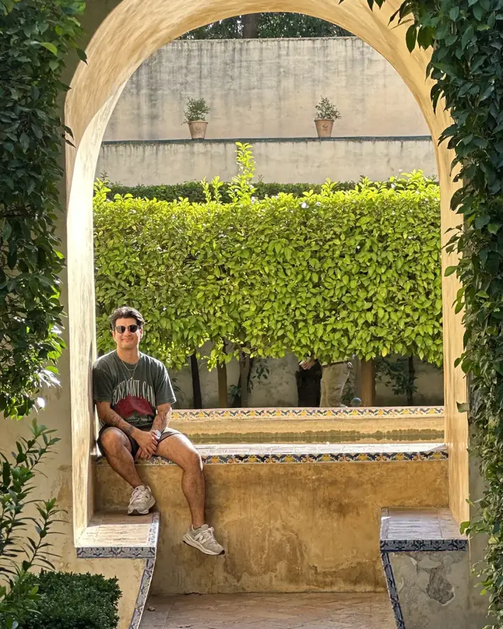 Sebastian Cosentino sitting in a garden archway